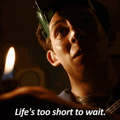 a man holding a candle with the words life 's too short to wait