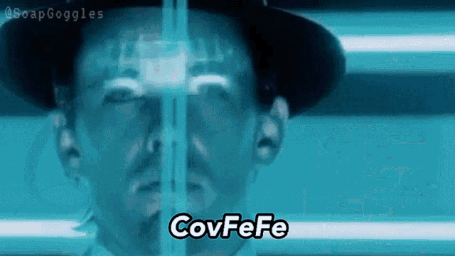 a man in a hat is looking through a window with the words covfefe written on the bottom