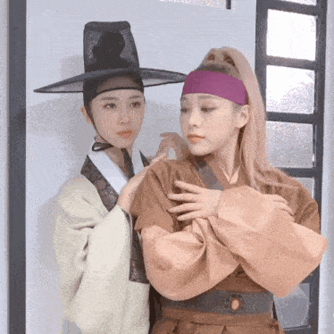a woman in a purple headband is standing next to another woman