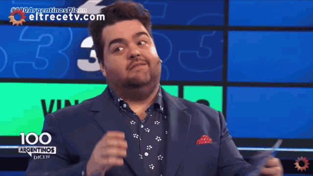a man in a suit is standing in front of a screen that says 100 argentinas