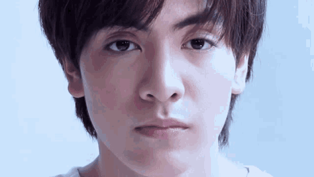 a close up of a young man 's face with a serious expression .