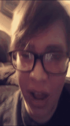 a close up of a person wearing glasses and a black shirt