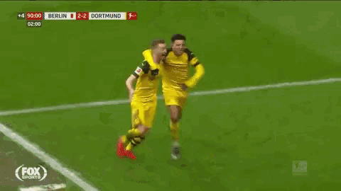 two soccer players are celebrating a goal on a fox sports broadcast .