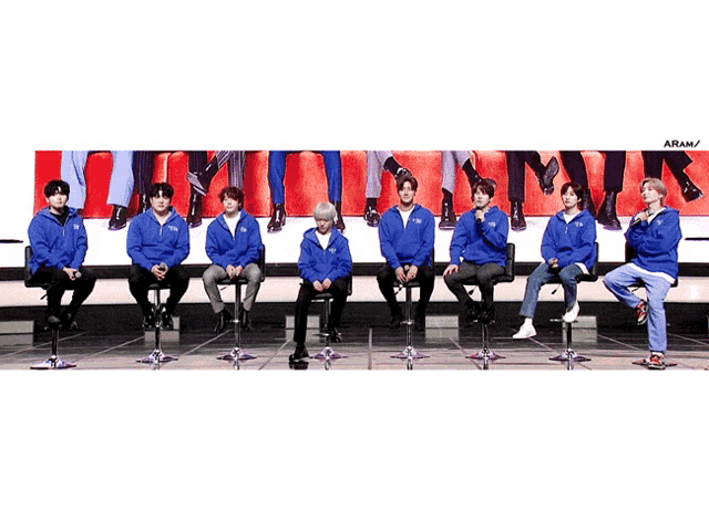 a group of people sitting in a row with the letters aram on the bottom right