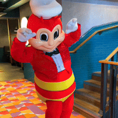 a mascot in a tuxedo is standing in front of a staircase