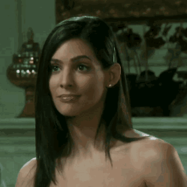 a woman without a shirt looks at the camera