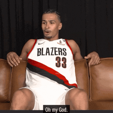 a man in a blazers jersey sits on a brown couch