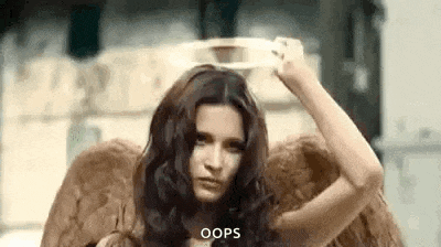 a woman with angel wings and a halo on her head is making a funny face .