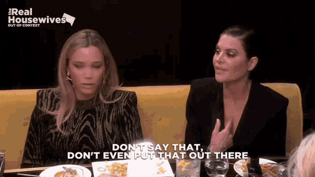 two women are sitting at a table and one of them is saying " don t say that "