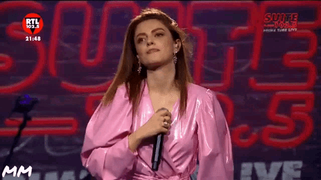 a woman in a pink robe stands in front of a rtl logo