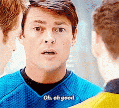a man in a blue shirt says oh , oh good while talking to two other men .