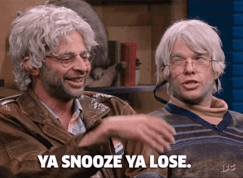 two men wearing wigs and glasses are sitting next to each other and one of them is saying ya snooze ya lose