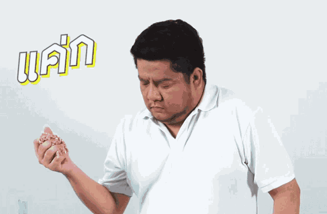 a man in a white shirt is brushing his teeth with a toothbrush in his mouth