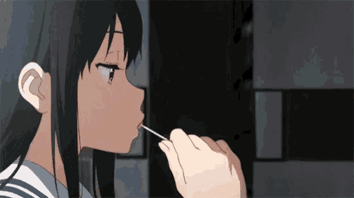 a person is applying lipstick to a girl 's lips with a brush .