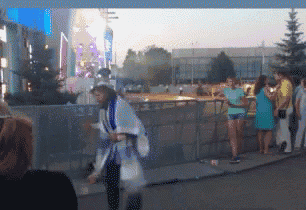 a blurred image of a woman standing in front of a fence