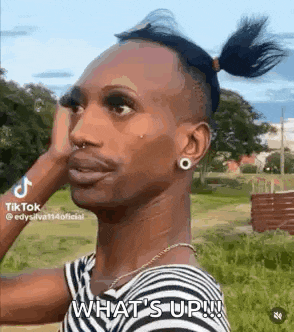 a man with a bun on his head is standing in a field .