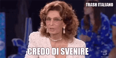a woman wearing glasses and a white dress says " credo di svenire "