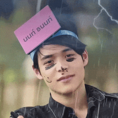 a young man with a pink card on his head that says ' uun ' on it