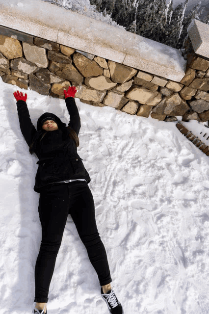 a woman is laying on her back in the snow