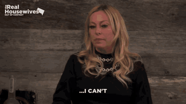 a woman says i can 't in front of a real housewives sign