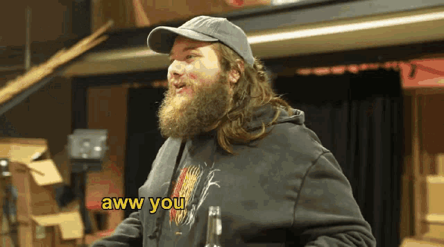a man with a beard is wearing a black sweatshirt that says aww you on it