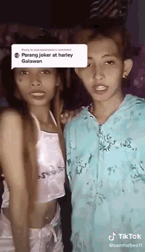 two girls are standing next to each other on a bed and talking to each other .