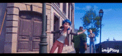 a woman in a blue helmet is standing in front of a building on a city street .
