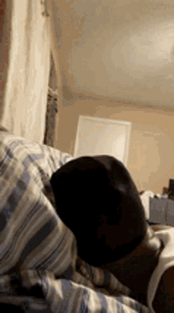a man is sleeping on a bed with his head on a pillow .