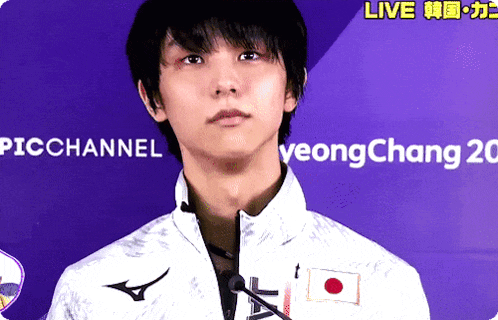 a young man stands in front of a sign that says live on it