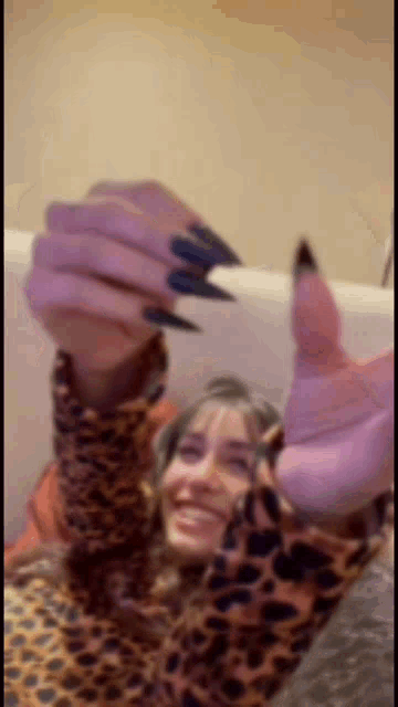 a woman with long black nails is taking a picture of herself .