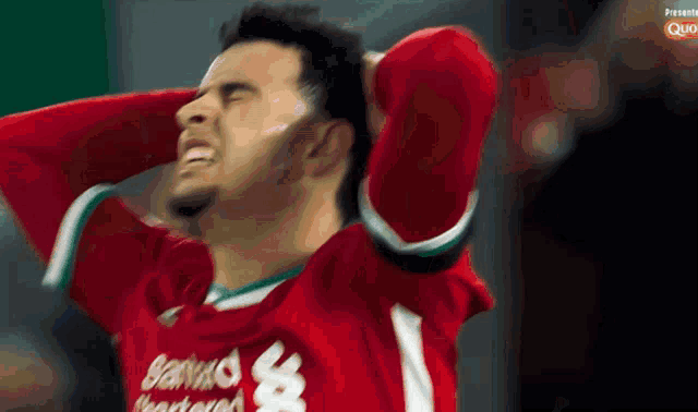 a man wearing a red shirt that says barclays on it