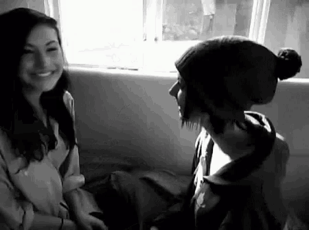 a man and a woman are sitting next to each other and smiling .