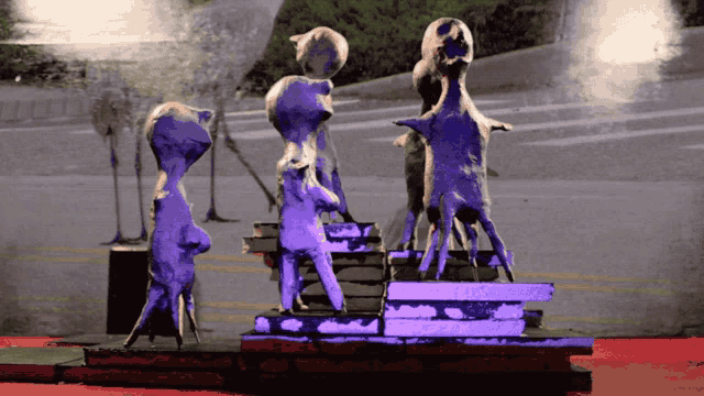a purple statue of a person standing on a podium with a purple background