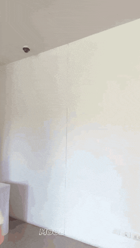 a woman is standing in front of a white wall and smiling