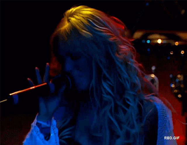 a woman singing into a microphone with the words rbd.gif in the lower right corner