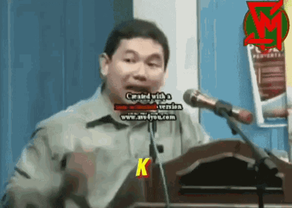 a man stands at a podium with a microphone and says created with a www.av-you.com