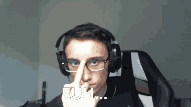 a man wearing headphones and glasses is making a funny face and says euh