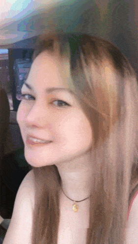 a close up of a woman 's face with a necklace on