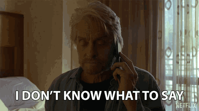 a man talking on a cell phone with the words " i don 't know what to say " behind him
