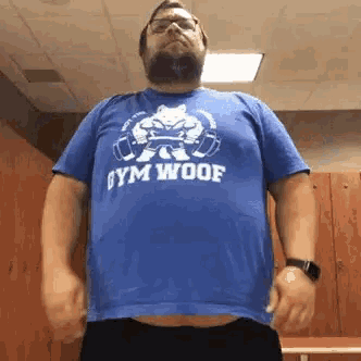 a man with a beard and glasses is wearing a blue shirt that says gym woof .