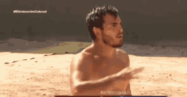 a man without a shirt is standing on a beach