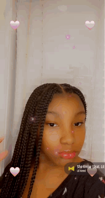 a girl with braids is wearing a black shirt that says she know feat lil keed