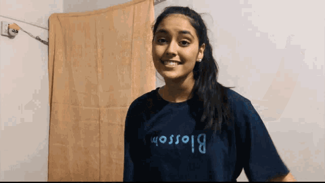 a girl wearing a blue shirt that says blossom smiles