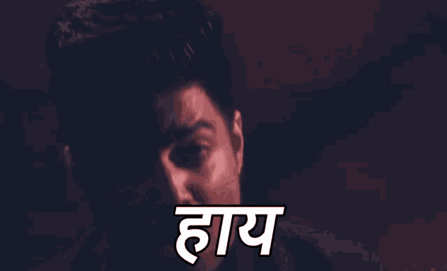 a close up of a man 's face with a caption in a dark room .