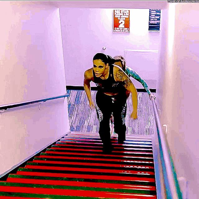 a woman is running up a set of stairs in front of a sign that says no pets allowed