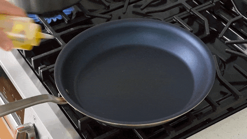 a person is pouring oil into a frying pan on the stove
