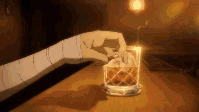 a person is lighting a cigarette in front of a glass of whiskey
