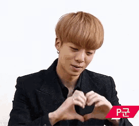 a man is making a heart shape with his hands .