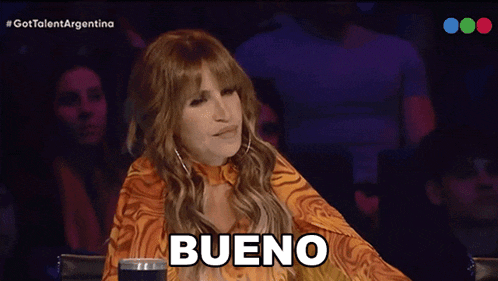 a woman sitting in front of a crowd with the words te miramos written on her face