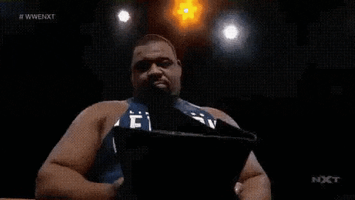 a man in a blue shirt is dancing in a ring .